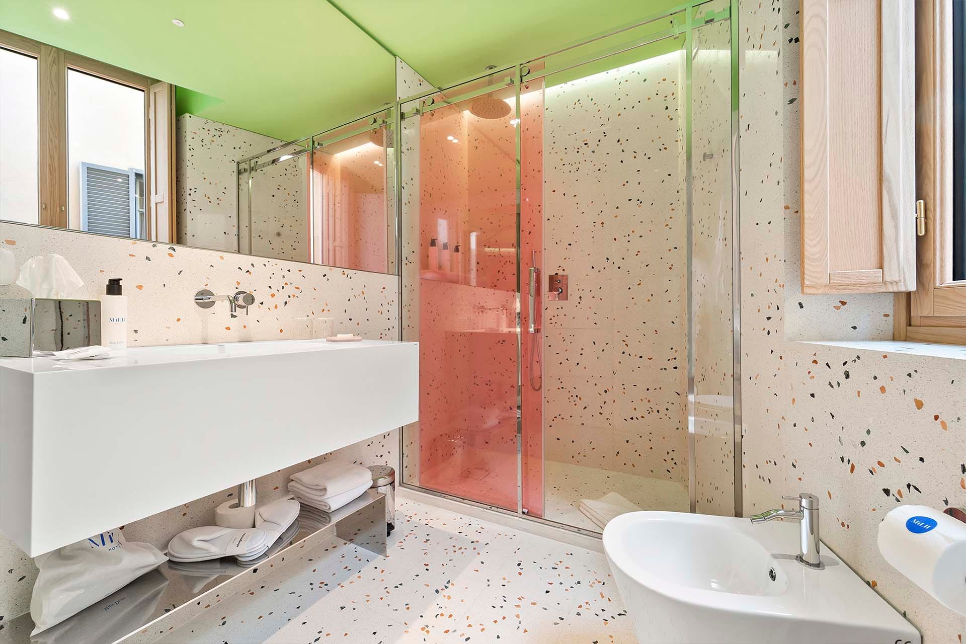 Detalle de Habitación Deluxe Doble con cama de matrimonio y espejo redondo en la pared del Hotel Milu en Milán