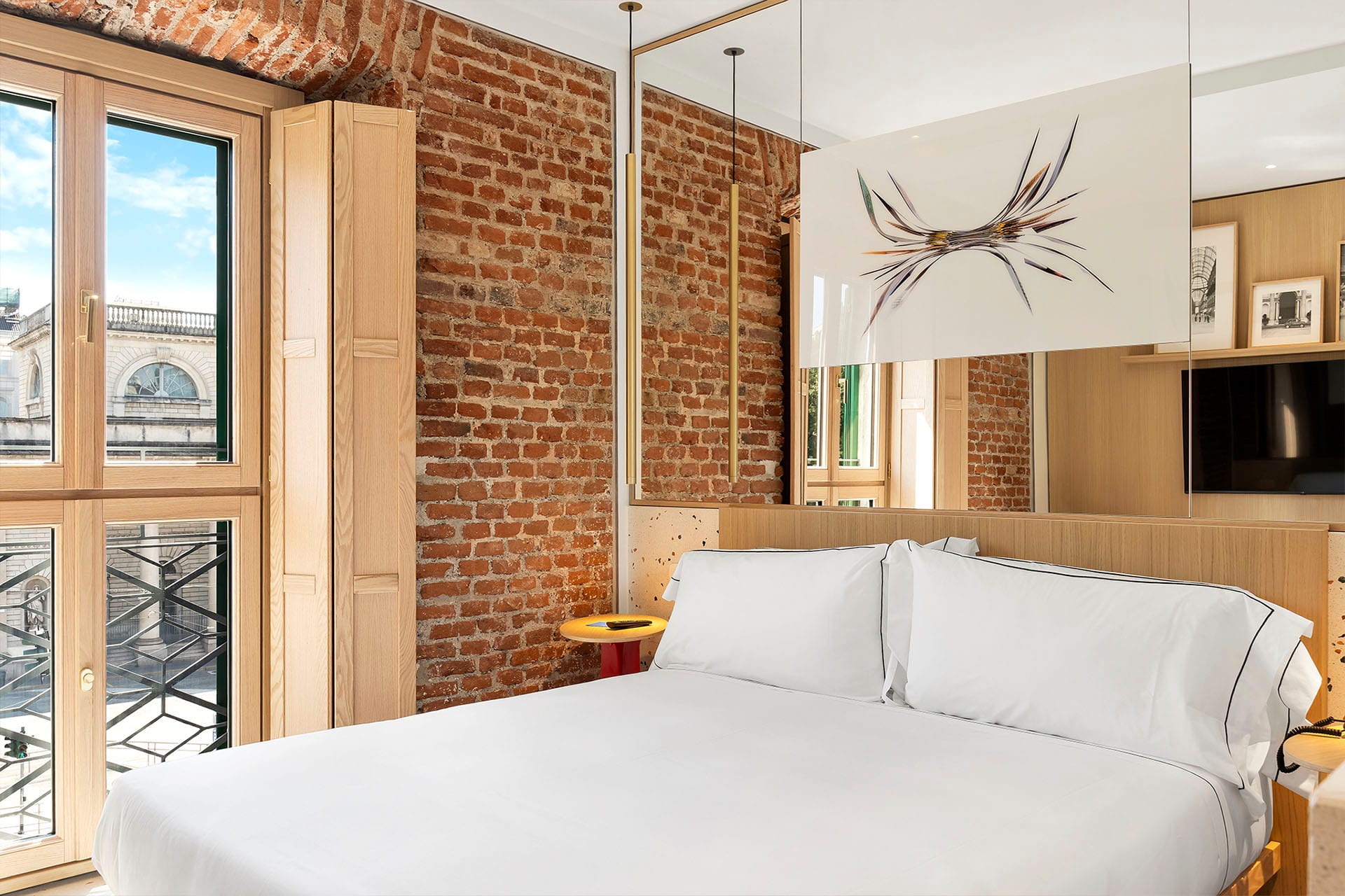 Detalle de Habitación Superior Matrimonial con cama de matrimonio y pared de ladrillos del Hotel Milu en Milán