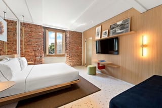 Dettaglio camera Comfort Tripla con letto matrimoniale e comodini a lato Hotel Milu Milano