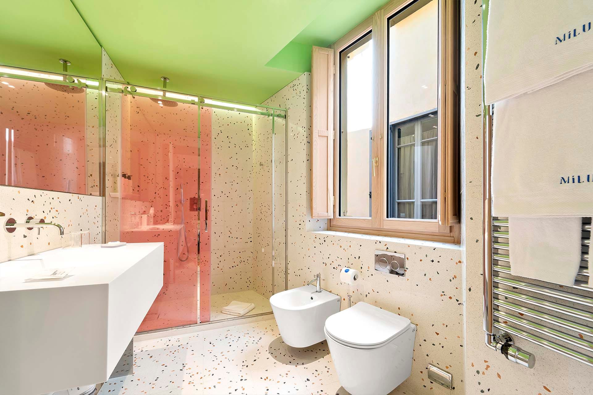 Detalle de Habitación Deluxe Doble con cama de matrimonio y pared de ladrillos a la vista del Hotel Milu en Milán