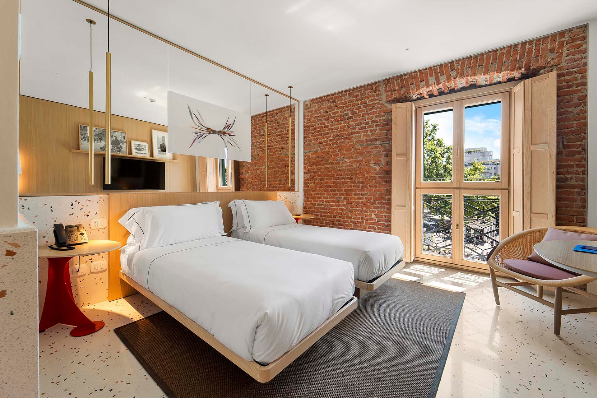 Detalle de Habitación Deluxe Twin con camas separadas y mesitas a los lados del Hotel Milu en Milán