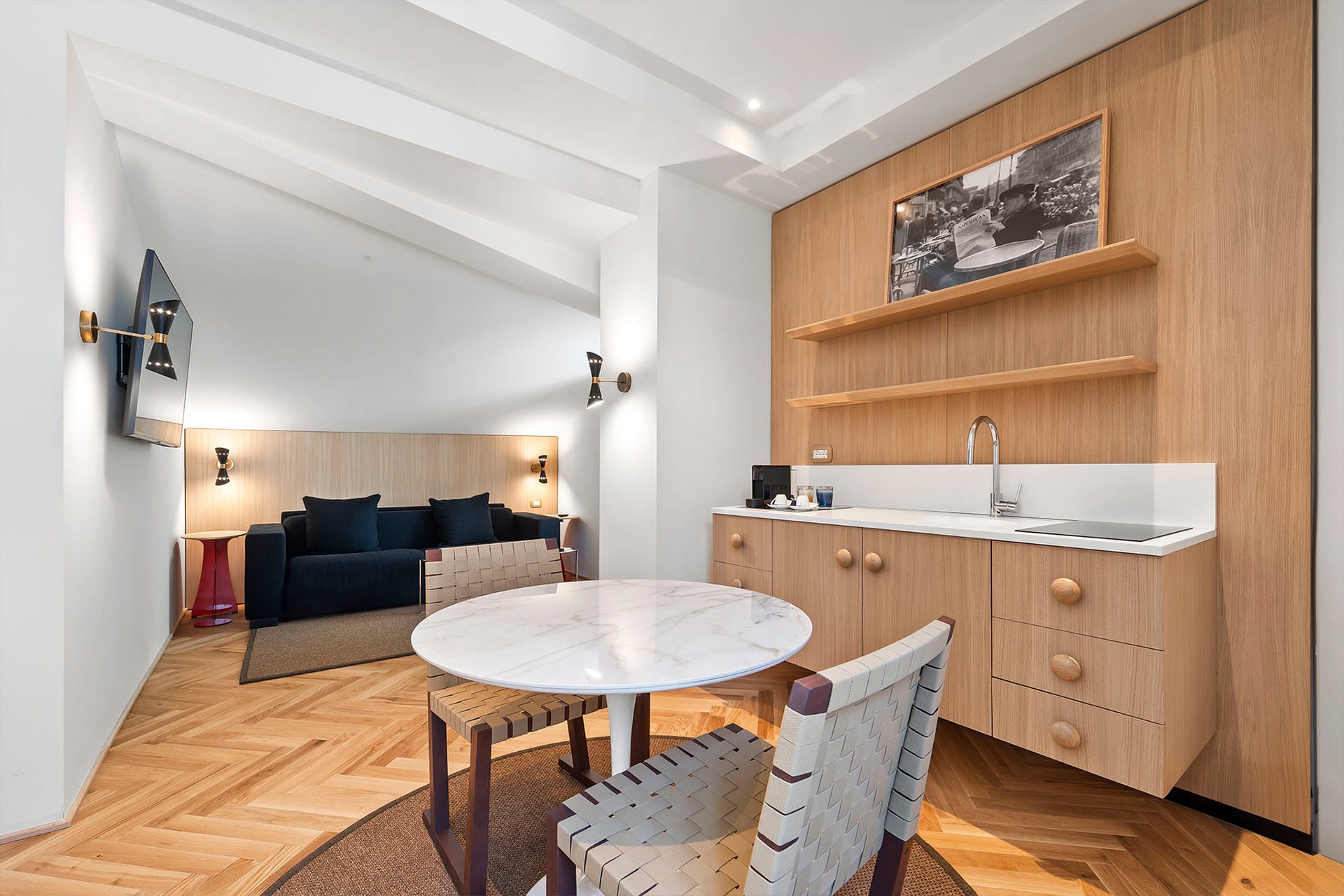 Detalle de Habitación Cuádruple Prestige con sofá y TV de pantalla plana, kitchenette con mesa de comedor