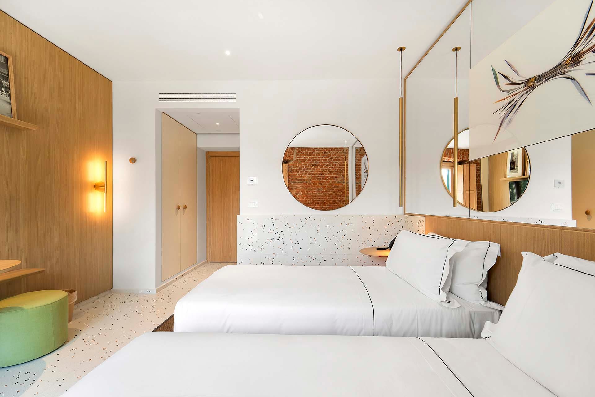 Detalle de Habitación Deluxe Twin con ventana y pared de ladrillos a la vista del Hotel Milu en Milán